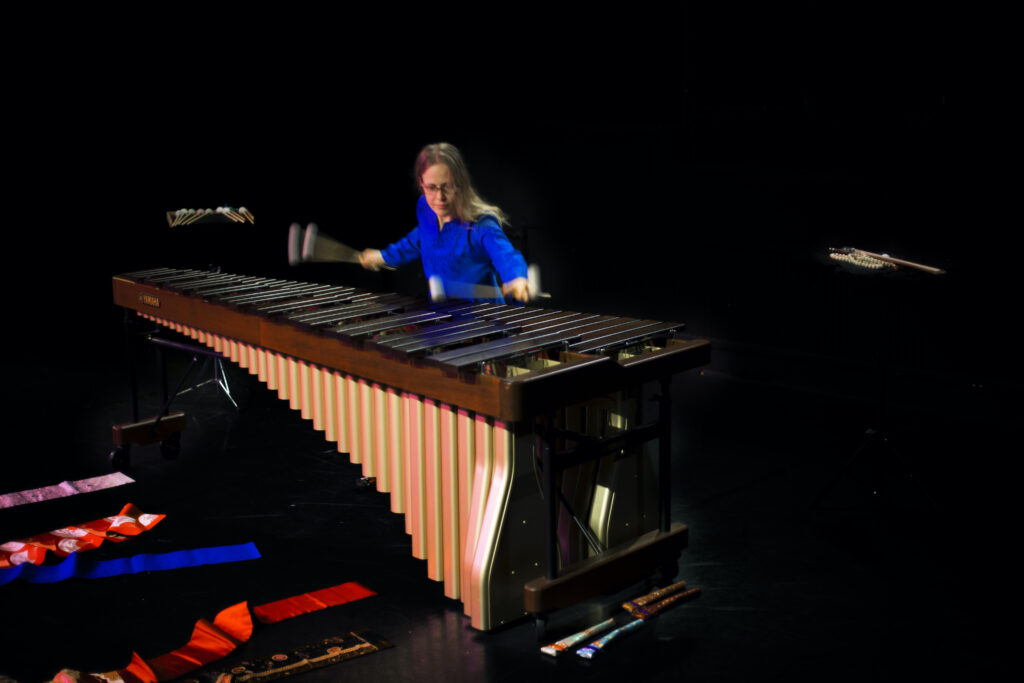 Fokuserad Ellen spelar marimba i blå blus